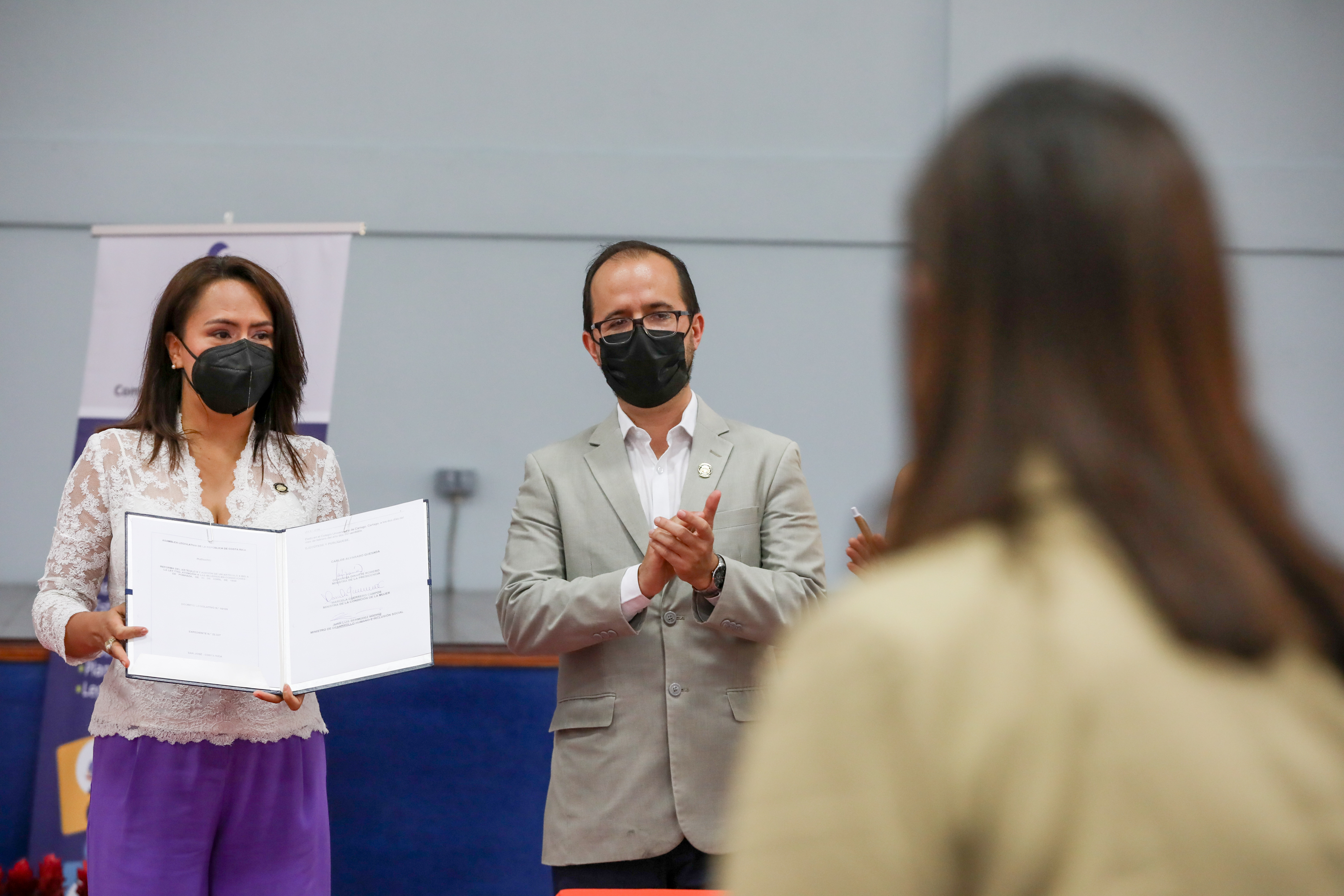 La Ministra de la Presidencia Geanina Dinarte Romero y el Ministro de Desarrollo Humano, Juan Luis Bermúdez Madriz, muestran la ley y su firma