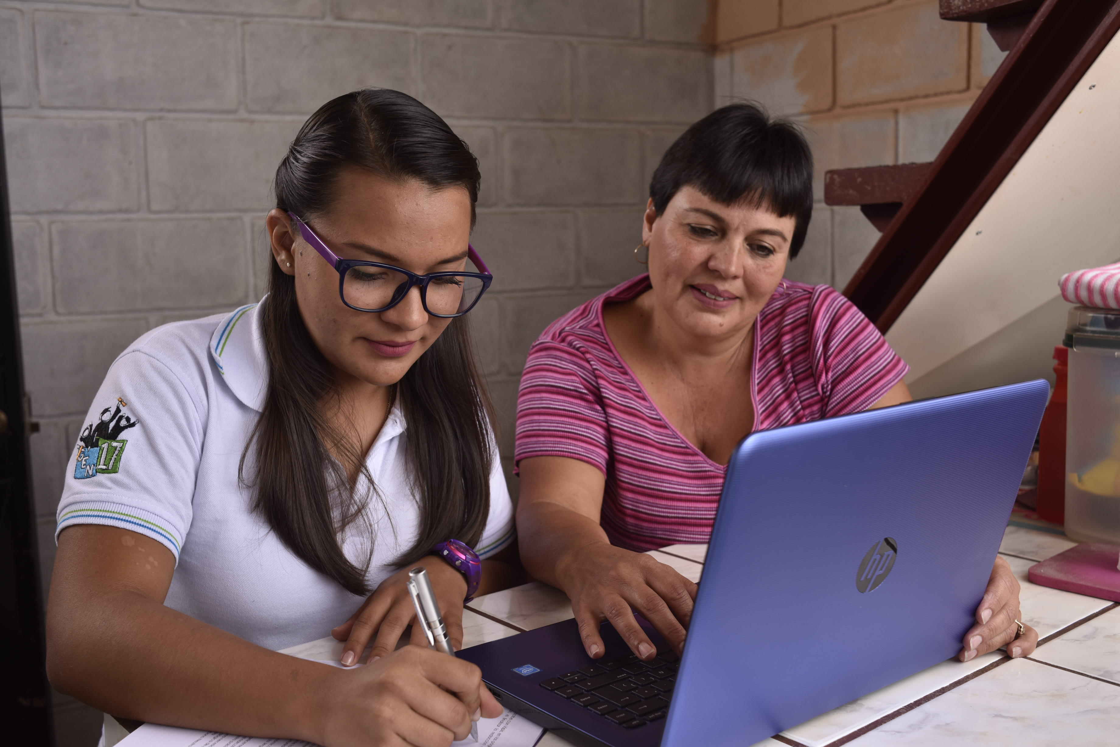 Foto de madre e hija en labores de estudio.