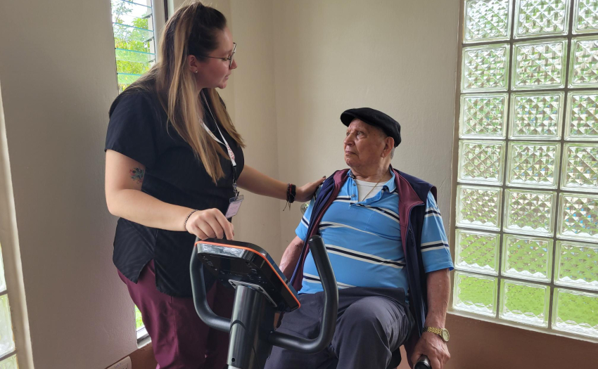 Mujer cuidadora atiende a adulto mayor en la Asociación Cartaginesa de Atención a Ciudadanos de la Tercera Edad